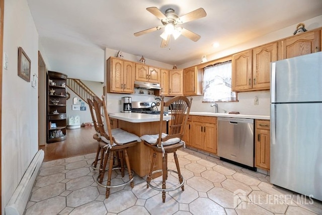 kitchen featuring stainless steel appliances, baseboard heating, light countertops, ceiling fan, and under cabinet range hood