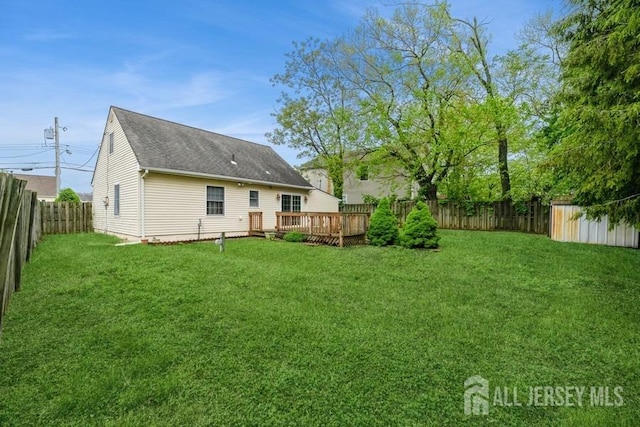 rear view of property with a deck and roof with shingles