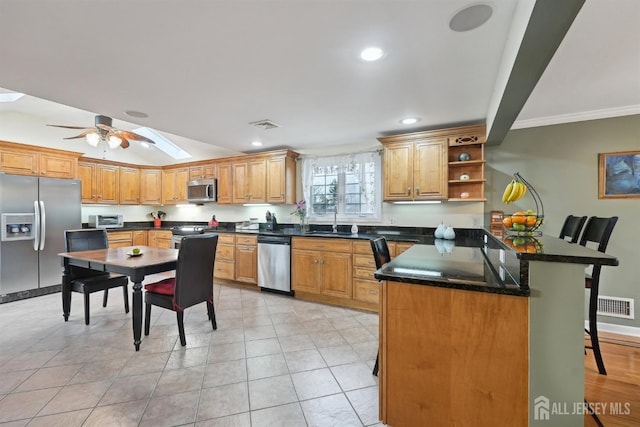 kitchen with visible vents, a breakfast bar, a peninsula, a sink, and stainless steel appliances