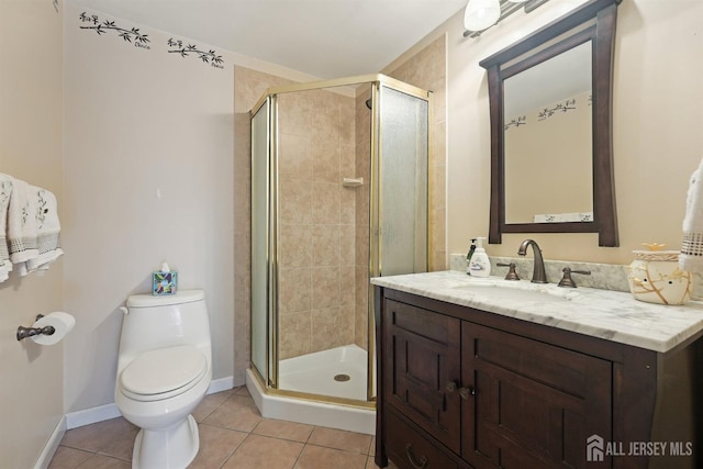 bathroom with tile patterned flooring, baseboards, toilet, a stall shower, and vanity