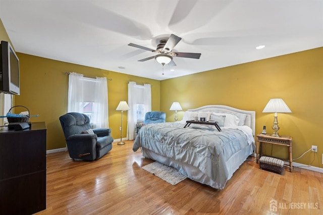 bedroom featuring a ceiling fan, baseboards, and light wood-type flooring