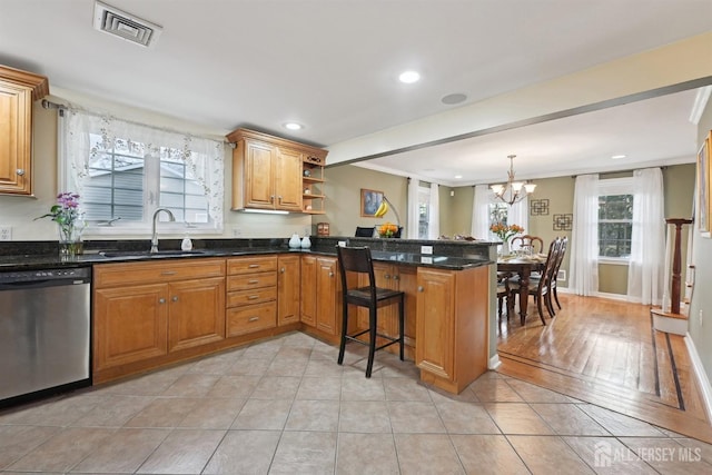 kitchen featuring a sink, visible vents, dishwasher, and a wealth of natural light