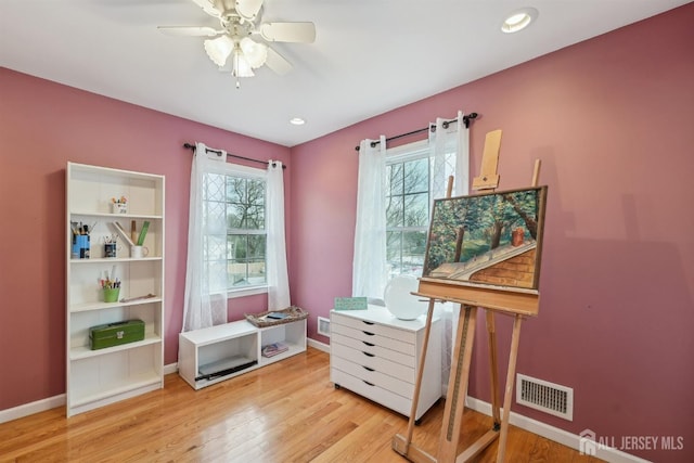 misc room with wood finished floors, visible vents, and baseboards