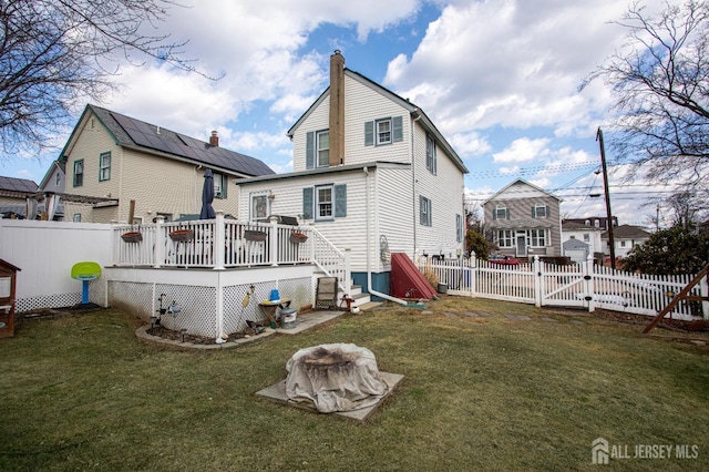 rear view of house with a yard and a deck