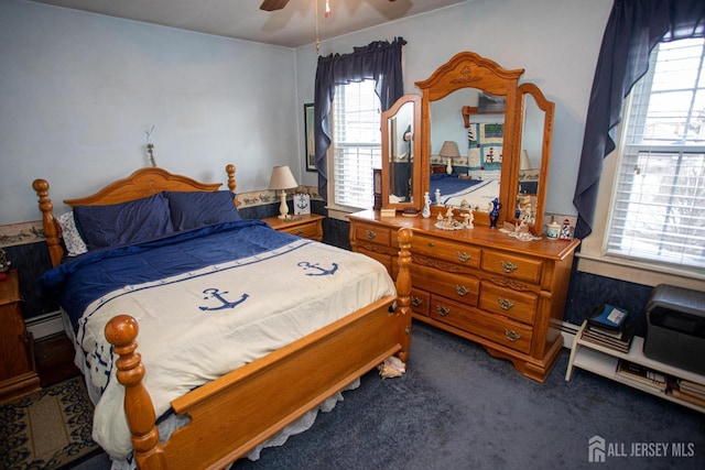 carpeted bedroom with a baseboard radiator and ceiling fan