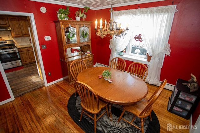 dining space with a notable chandelier, a baseboard radiator, and dark hardwood / wood-style floors