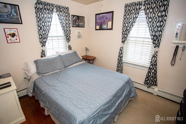 bedroom with multiple windows and baseboard heating