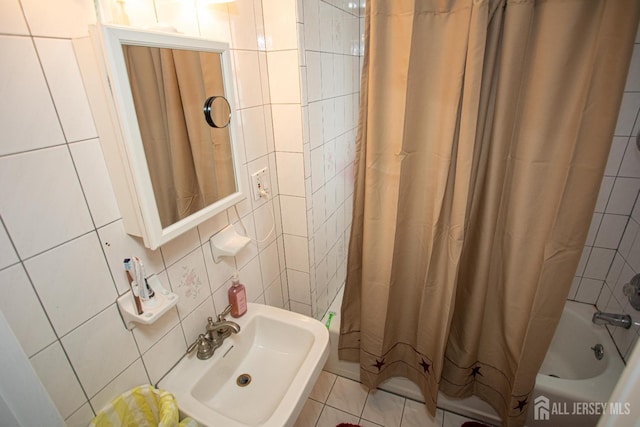 bathroom featuring shower / bath combo, sink, tile walls, and backsplash