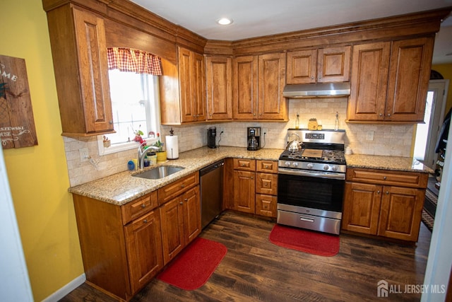 kitchen featuring dark hardwood / wood-style flooring, sink, light stone counters, and appliances with stainless steel finishes