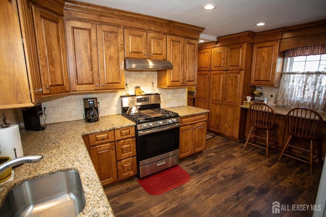 kitchen featuring sink, dark hardwood / wood-style flooring, decorative backsplash, light stone counters, and stainless steel gas range