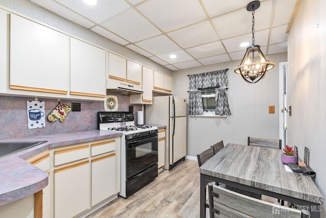 164 Holly St, Port Reading, NJ 07064 - kitchen featuring gas stove, under cabinet range hood, a chandelier, light wood-style floors, and recessed lighting