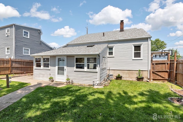 164 Holly St, Port Reading, NJ 07064 - back of house with a fenced backyard, a chimney, and a shingled roof