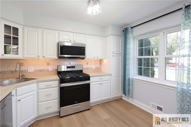 416 Wallace St Unit 416, Edison, NJ 08817 - kitchen featuring stainless steel appliances, a sink, light wood-style flooring, light countertops, and glass insert cabinets