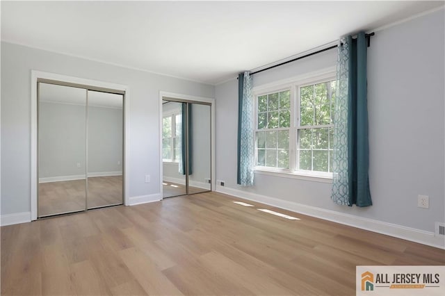 416 Wallace St Unit 416, Edison, NJ 08817 - unfurnished bedroom with two closets, wood finished floors, baseboards, and ornamental molding