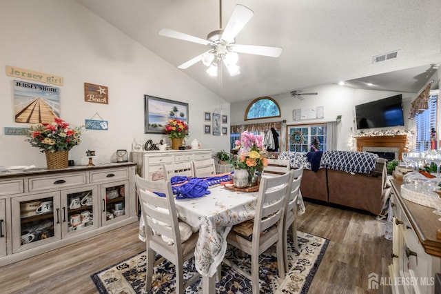 1617 Sweetbay Dr, Toms River, NJ 08755 - dining room featuring a ceiling fan, lofted ceiling, light wood-type flooring, and a fireplace