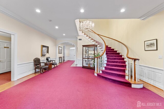 foyer featuring recessed lighting, crown molding, and stairs