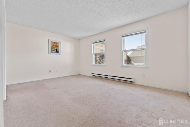 carpeted empty room with baseboards, a baseboard heating unit, and a textured ceiling