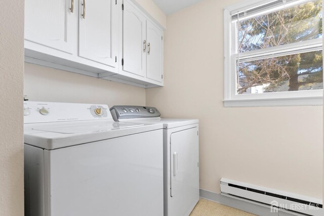 clothes washing area with separate washer and dryer, baseboard heating, and cabinet space