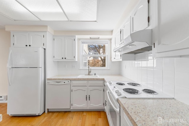 kitchen with white appliances, white cabinets, light wood-type flooring, under cabinet range hood, and a sink