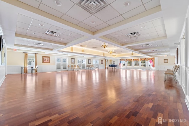 workout room with wood finished floors, visible vents, and an inviting chandelier