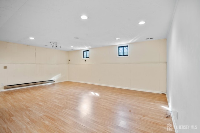 basement with baseboard heating, wood finished floors, recessed lighting, and baseboards