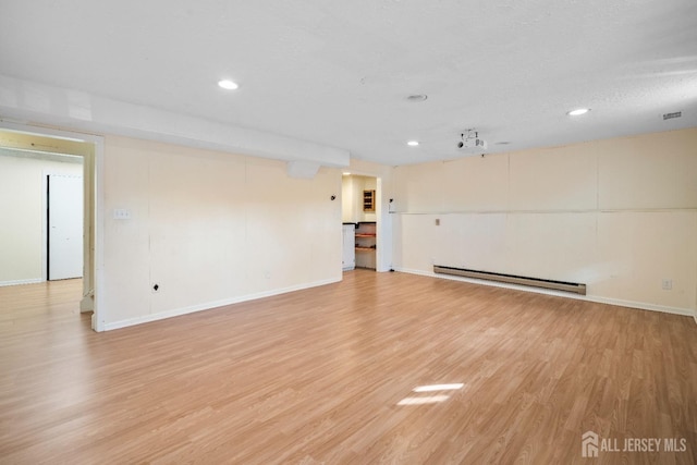 unfurnished room featuring baseboard heating, baseboards, light wood finished floors, and recessed lighting