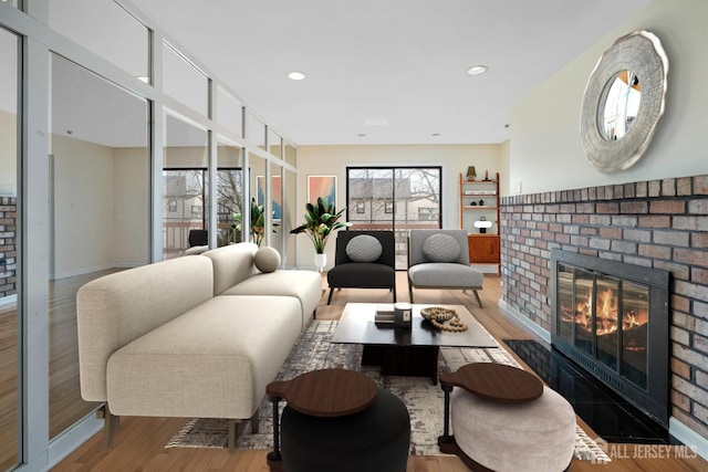 living area with a fireplace, wood finished floors, baseboards, and recessed lighting