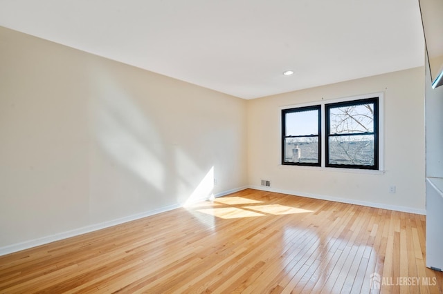 empty room with hardwood / wood-style flooring and baseboards