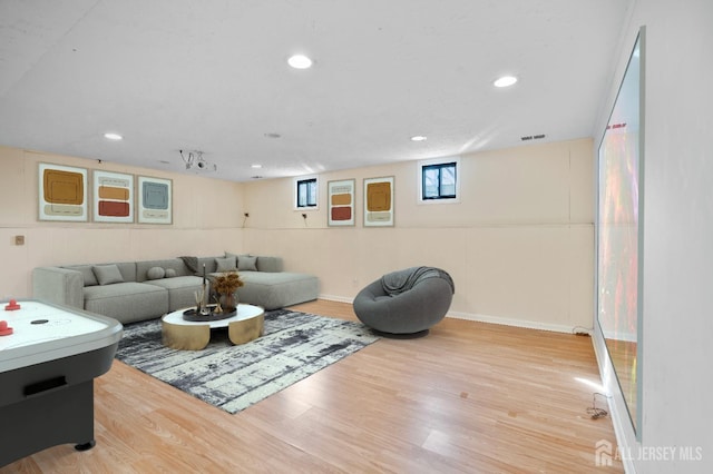living area featuring wood finished floors, baseboards, and recessed lighting