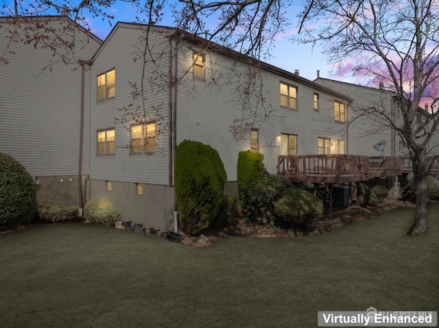 back of property featuring a lawn, a wooden deck, and cooling unit