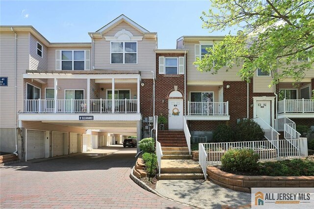 516 Great Beds Ct, Perth Amboy, NJ 08861 - view of property featuring driveway, an attached garage, brick siding, and stairs