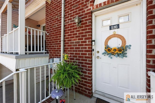 516 Great Beds Ct, Perth Amboy, NJ 08861 - doorway to property featuring brick siding and covered porch