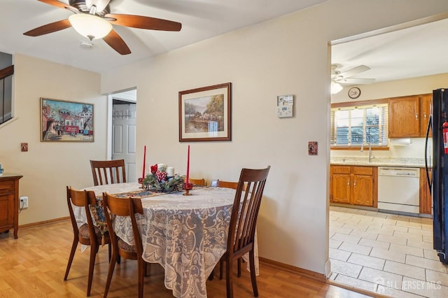 dining area featuring sink, light wood-type flooring, and ceiling fan