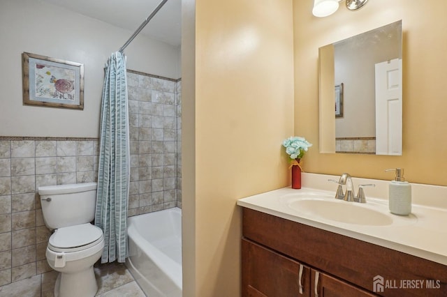 full bathroom with toilet, shower / bath combo, vanity, and tile walls