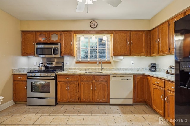 kitchen featuring sink, ceiling fan, light stone countertops, and appliances with stainless steel finishes