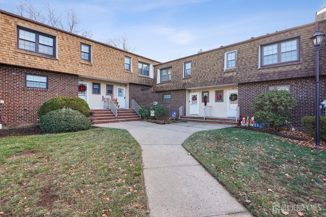 townhome / multi-family property featuring a front lawn