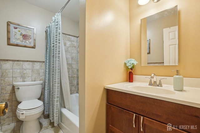 full bathroom featuring toilet, shower / tub combo, vanity, and tile walls