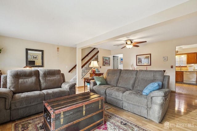 living room featuring sink, ceiling fan, and light wood-type flooring