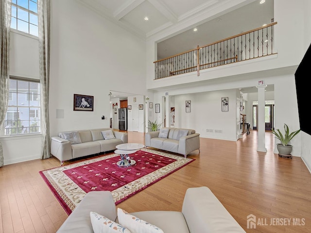 6 Condor Ct, South Brunswick, NJ 08852 - living area featuring a high ceiling, wood finished floors, plenty of natural light, beamed ceiling, and decorative columns