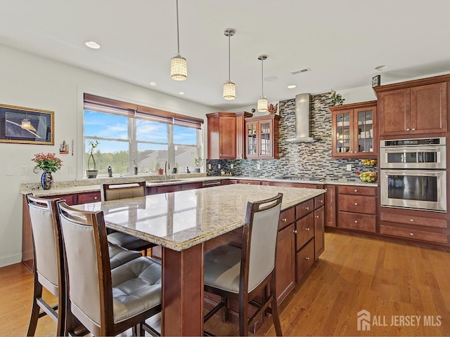 6 Condor Ct, South Brunswick, NJ 08852 - kitchen with wall chimney range hood, stainless steel appliances, a center island, light wood finished floors, and a sink