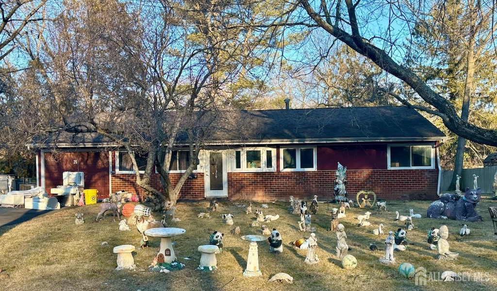 view of front of property featuring brick siding and roof with shingles