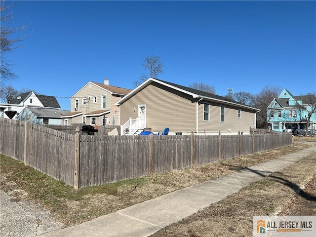 view of side of property featuring a residential view and a fenced front yard