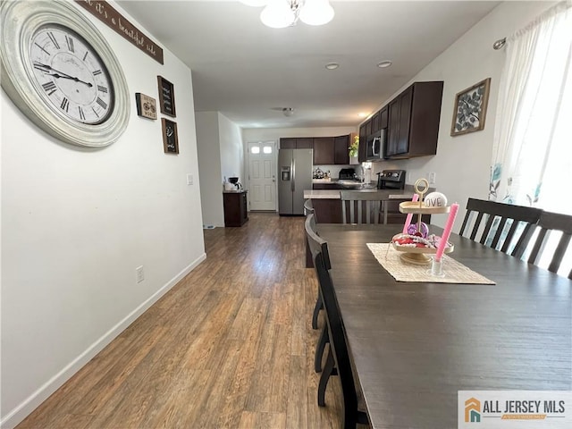 dining area featuring dark wood-style floors and baseboards