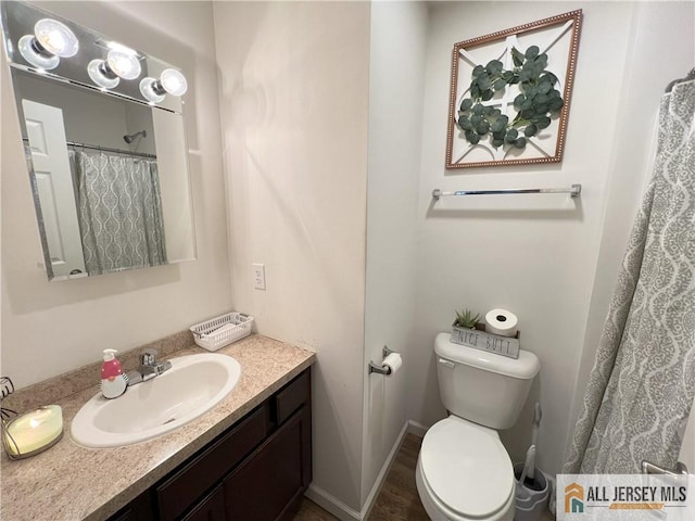 bathroom featuring vanity, toilet, a shower with curtain, and baseboards