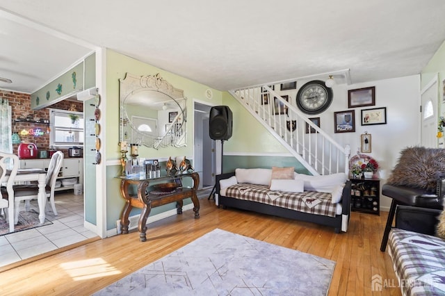 living area featuring stairs, wood-type flooring, and baseboards
