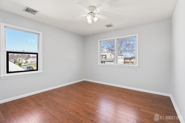 spare room featuring baseboards, ceiling fan, and wood finished floors