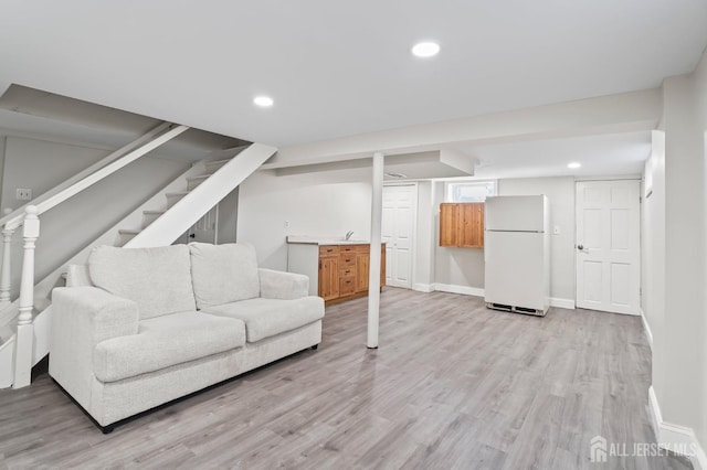 living room featuring light wood finished floors, baseboards, and recessed lighting