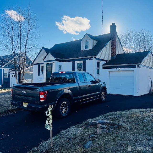 view of front of house with a chimney and an attached garage