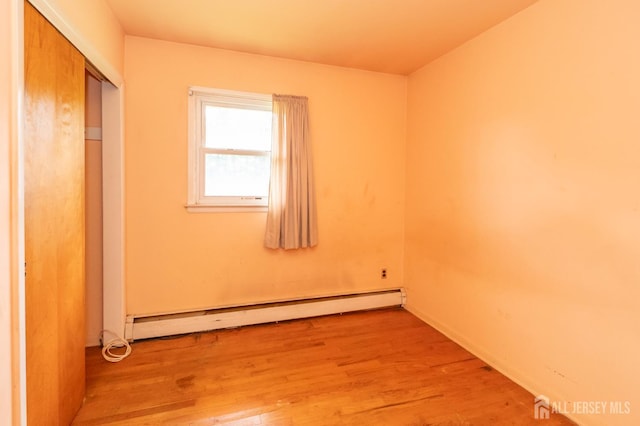 140 Prospect Plains Rd, Monroe, NJ 08831 - unfurnished bedroom featuring a baseboard heating unit, wood finished floors, and a closet