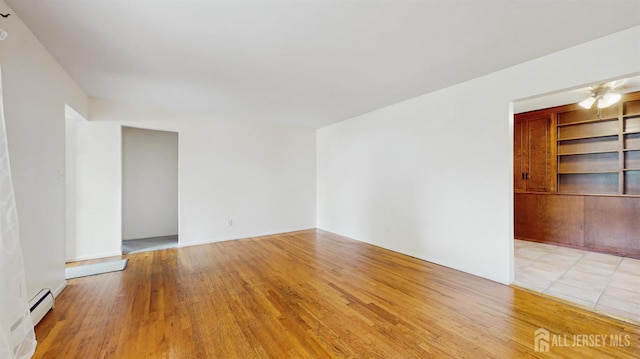 131 Hazelwood Ave, Metuchen, NJ 08840 - unfurnished room featuring baseboard heating, light wood finished floors, built in shelves, and ceiling fan